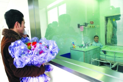 李亚峰手捧玫瑰站在层流病房外安慰黄燕。吴倪娜 摄 李亚峰手捧玫瑰站在层流病房外安慰黄燕。吴倪娜 摄